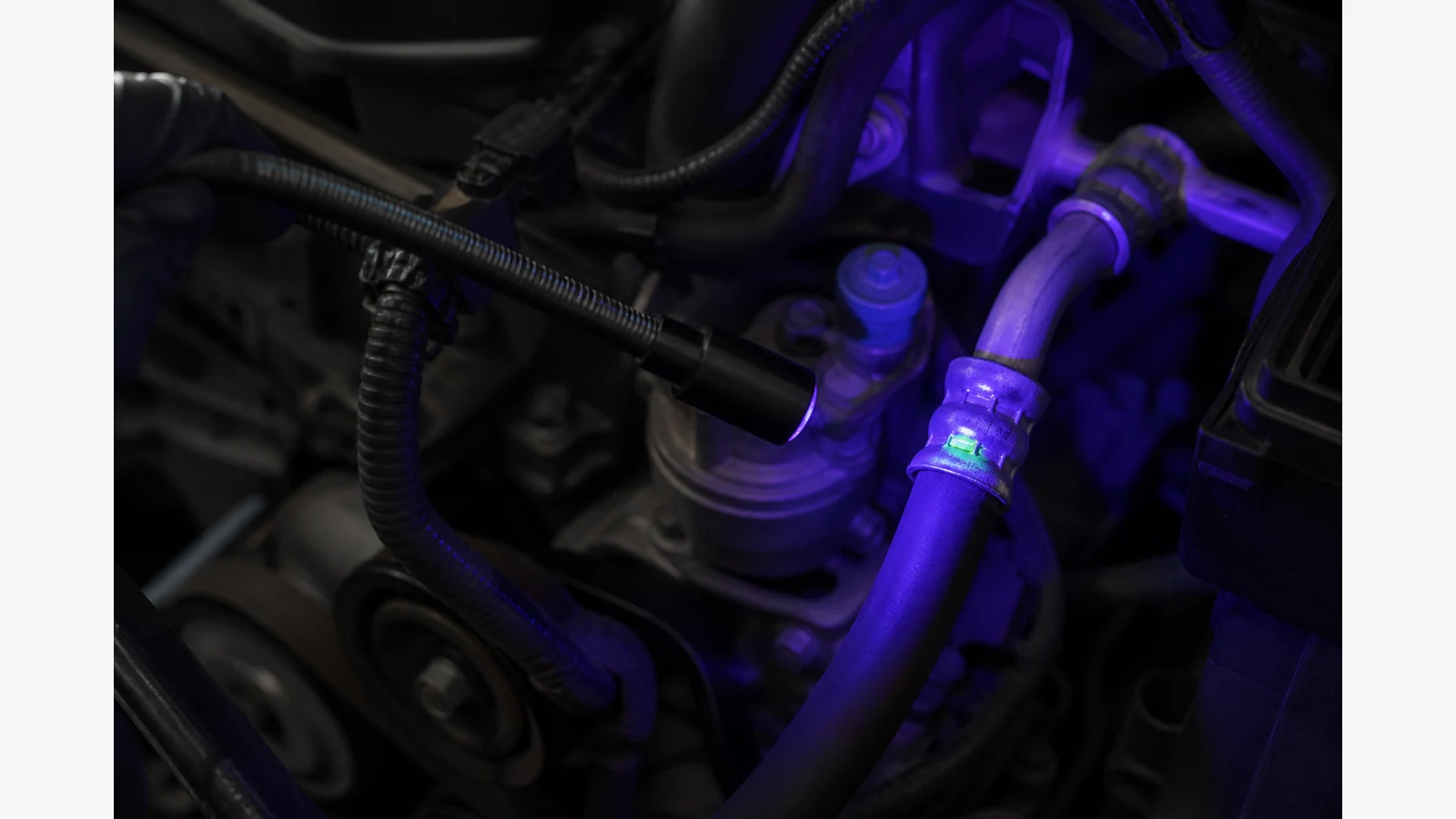 Automotive air-conditioning leak check using an electronic probe and UV dye glow on a hose joint